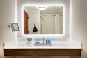 A bathroom with a white sink, a mirror, and a shower curtain.