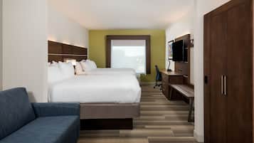 A hotel room with a large bed, a sofa, a TV, and a wardrobe.