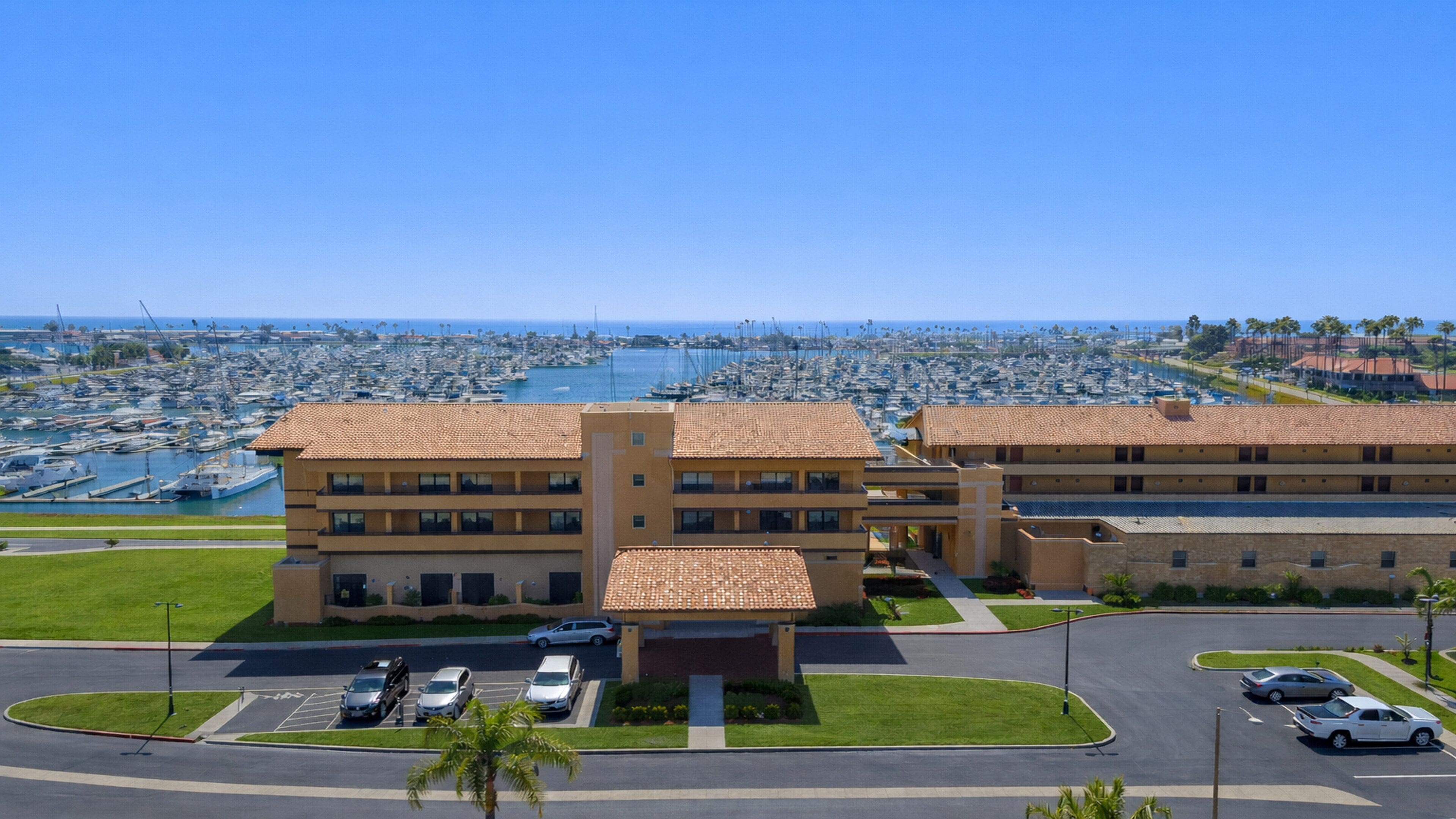 A hotel with a central courtyard, multiple floors, and a marina view.