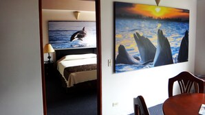 A room with a bed, a table, and a wall with two paintings of marine life. - Hotel Plaza Rosa (Medellin)