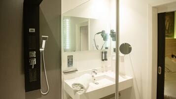 Une salle de bain moderne avec une douche, un lavabo et un miroir.