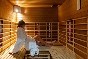Uma sauna com bancos de madeira e prateleiras cheias de garrafas.