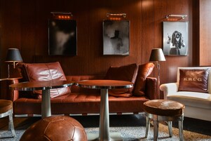 Una zona relax moderna con divani in pelle, un tavolino rotondo e un piccolo sgabello.