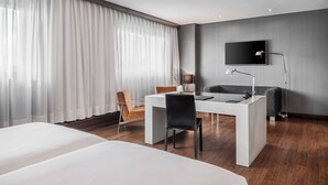 A modern hotel room with a large bed, a desk, a chair, and a TV mounted on the wall. - AC Hotel Porto by Marriott (Porto)