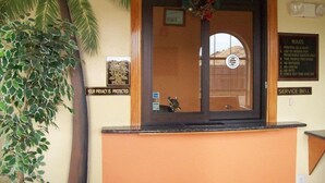 Un comptoir d’accueil avec un cadre en bois, un avis concernant la protection de la vie privée et une clochette pour signaler la présence d’un client.