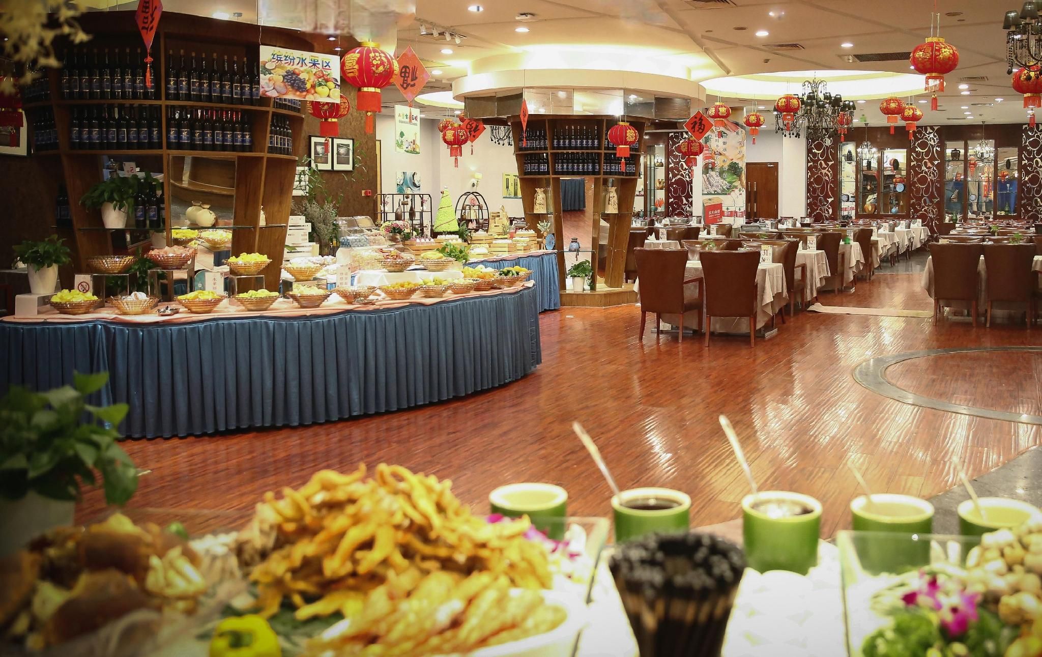 Restaurante com buffet, mesas e cadeiras.
