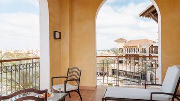 A balcony with a table, chairs, and a view of buildings.