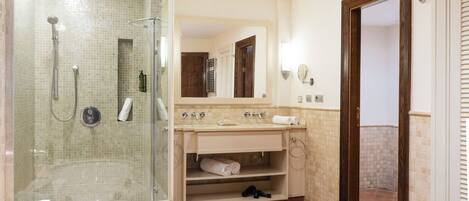 Un bagno con doccia vetrata, una vasca, un mobile lavabo con specchio e un appendiabiti per asciugamani.