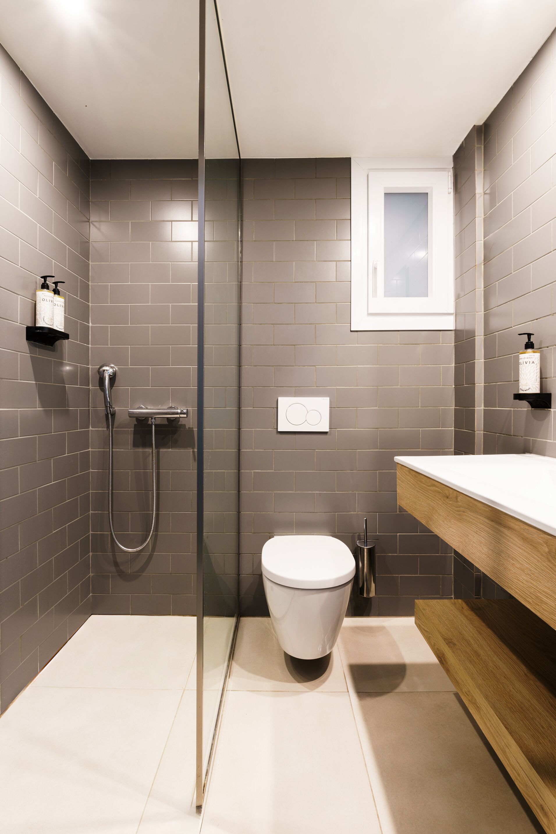 A modern bathroom with a shower, toilet, and vanity.
