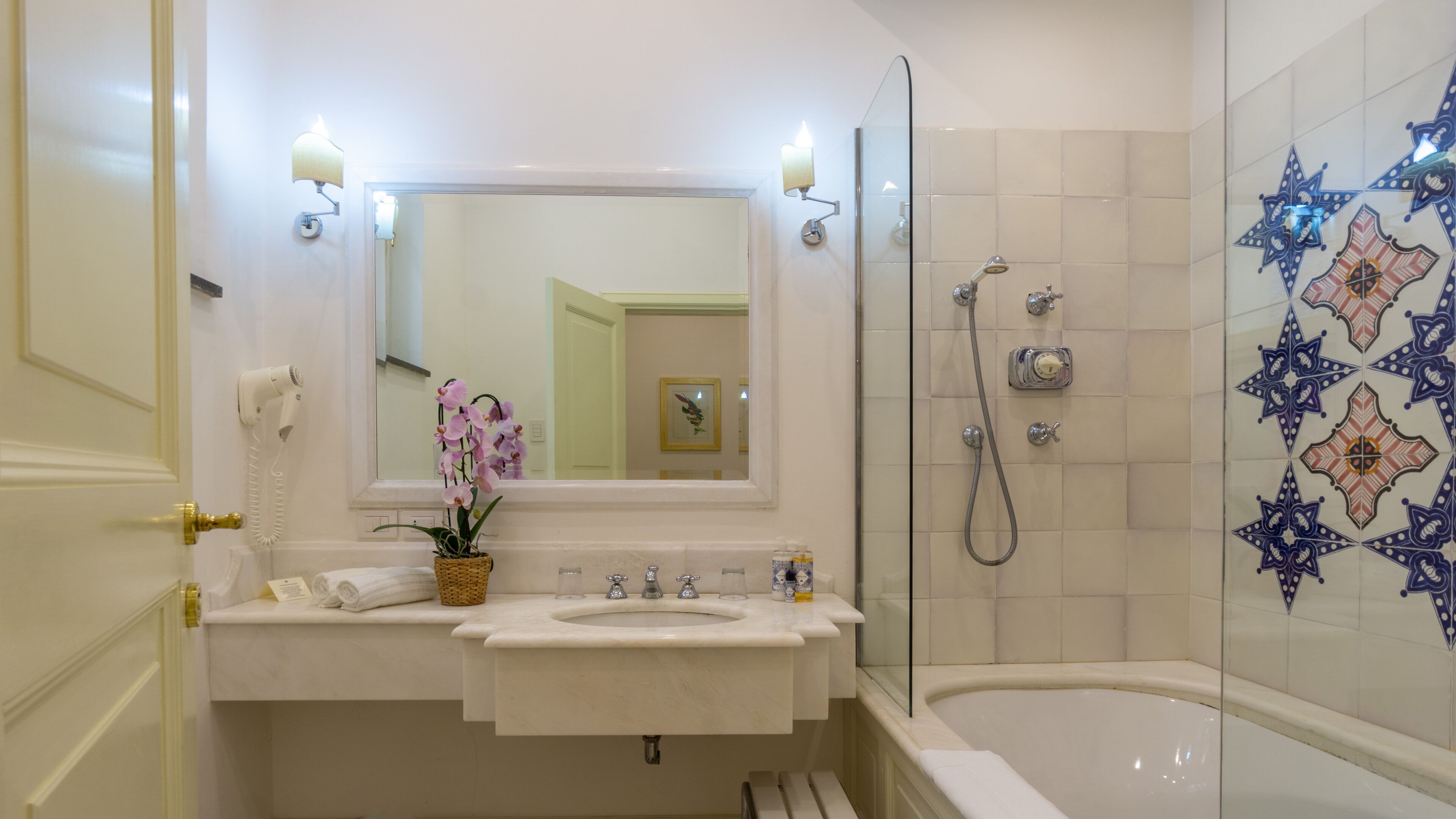 Baño con lavamanos, espejo y ducha.