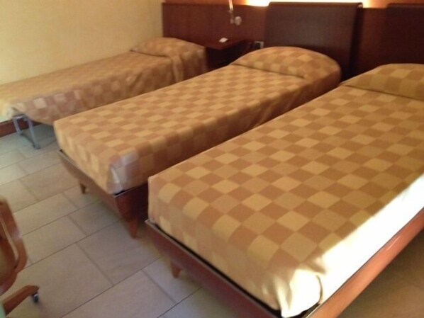 A hotel room with two single beds, a wooden headboard, a nightstand, and a chair. - Hotel San Marco (Carmagnola)