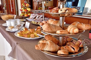 Un bufé con diversos alimentos, incluyendo pasteles, frutas y bebidas.
