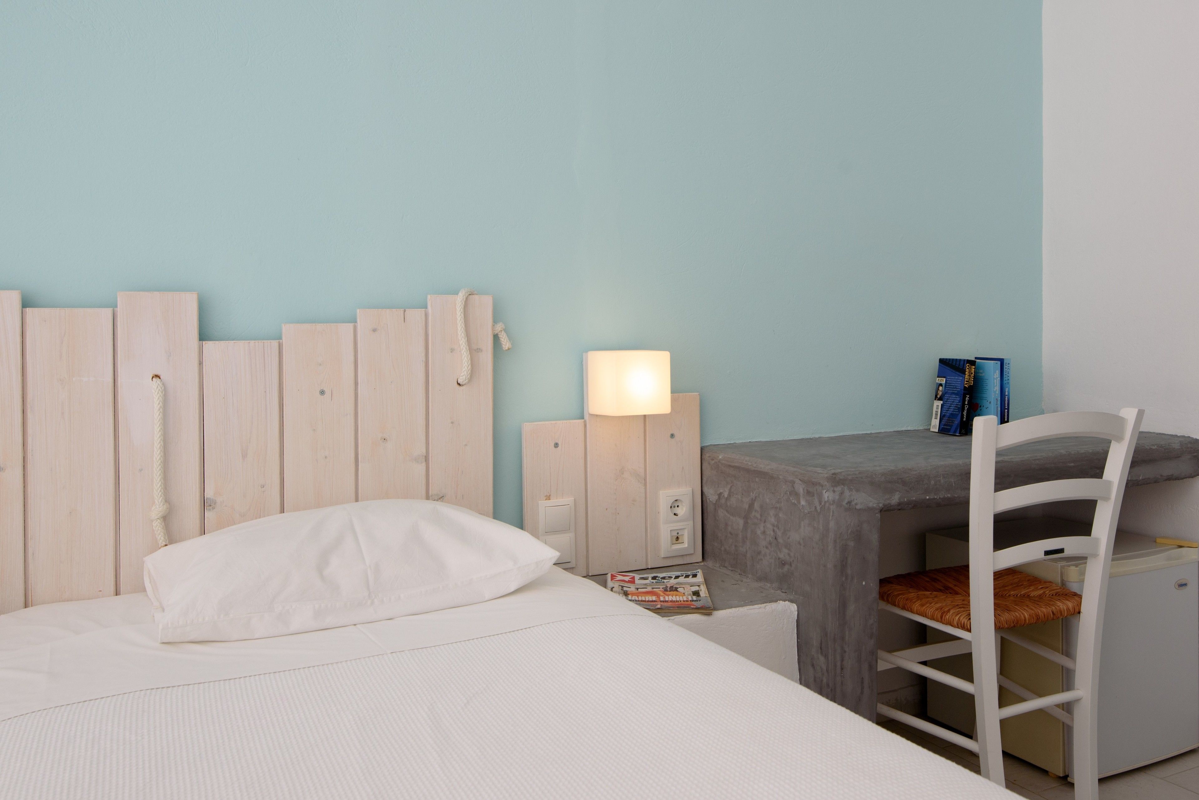 A room with a bed, a desk, and a chair.