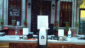A hotel reception desk with a sign indicating check-in and check-out times.