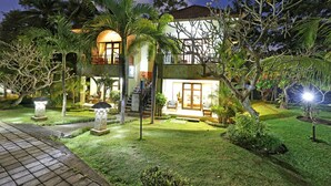 A two-story house with a balcony, surrounded by lush greenery and palm trees. - Bhanuswari Resort & Spa (Ubud)