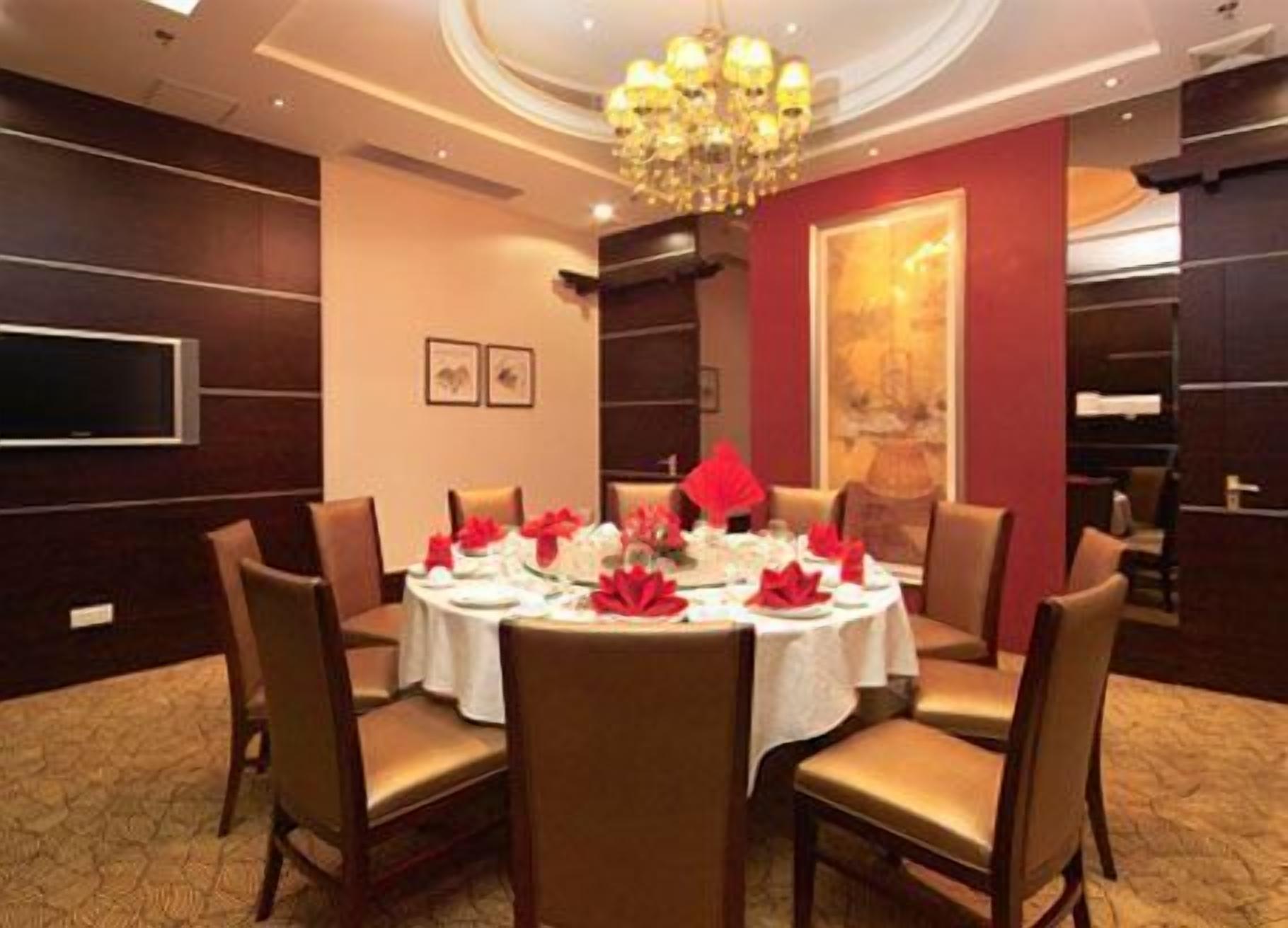 A dining room with a round table set for six, surrounded by six chairs.