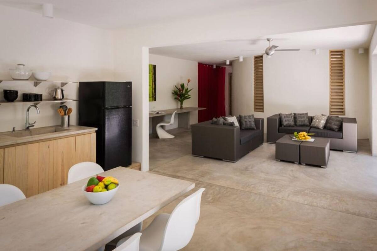 A modern apartment with a kitchen, dining area, and living room.
