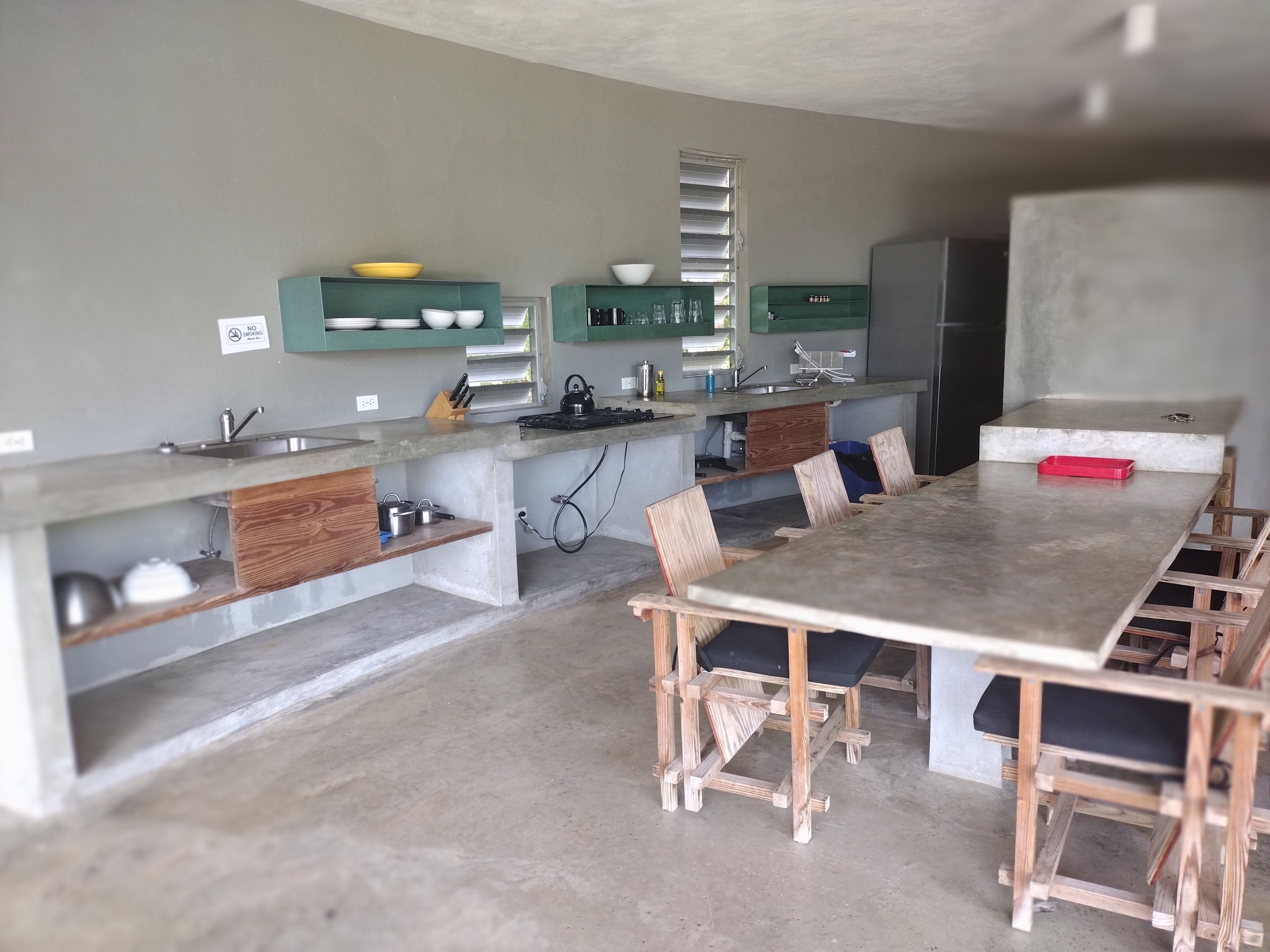 A kitchen with a large island, wooden chairs, and built-in cabinets.