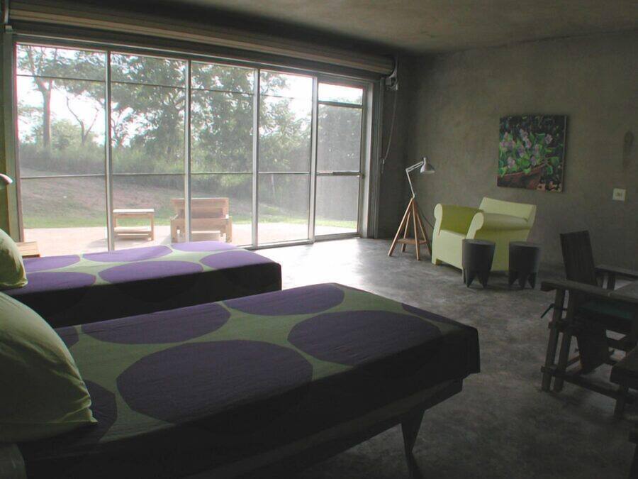 A room with two beds, a bench, a desk, and a chair.