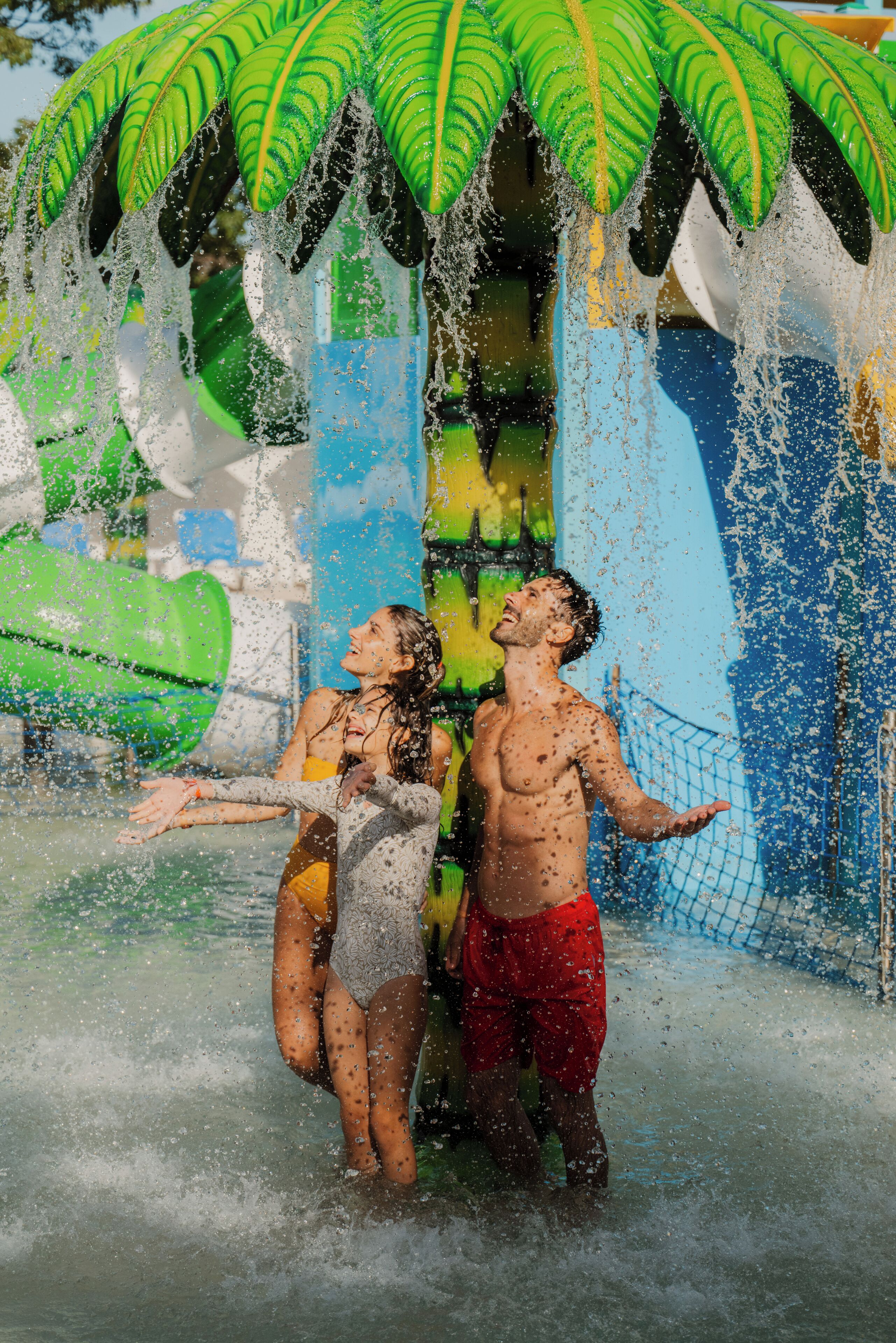 Een waterpark met een lange glijbaan en een afgesloten speelgebied voor waterpret.