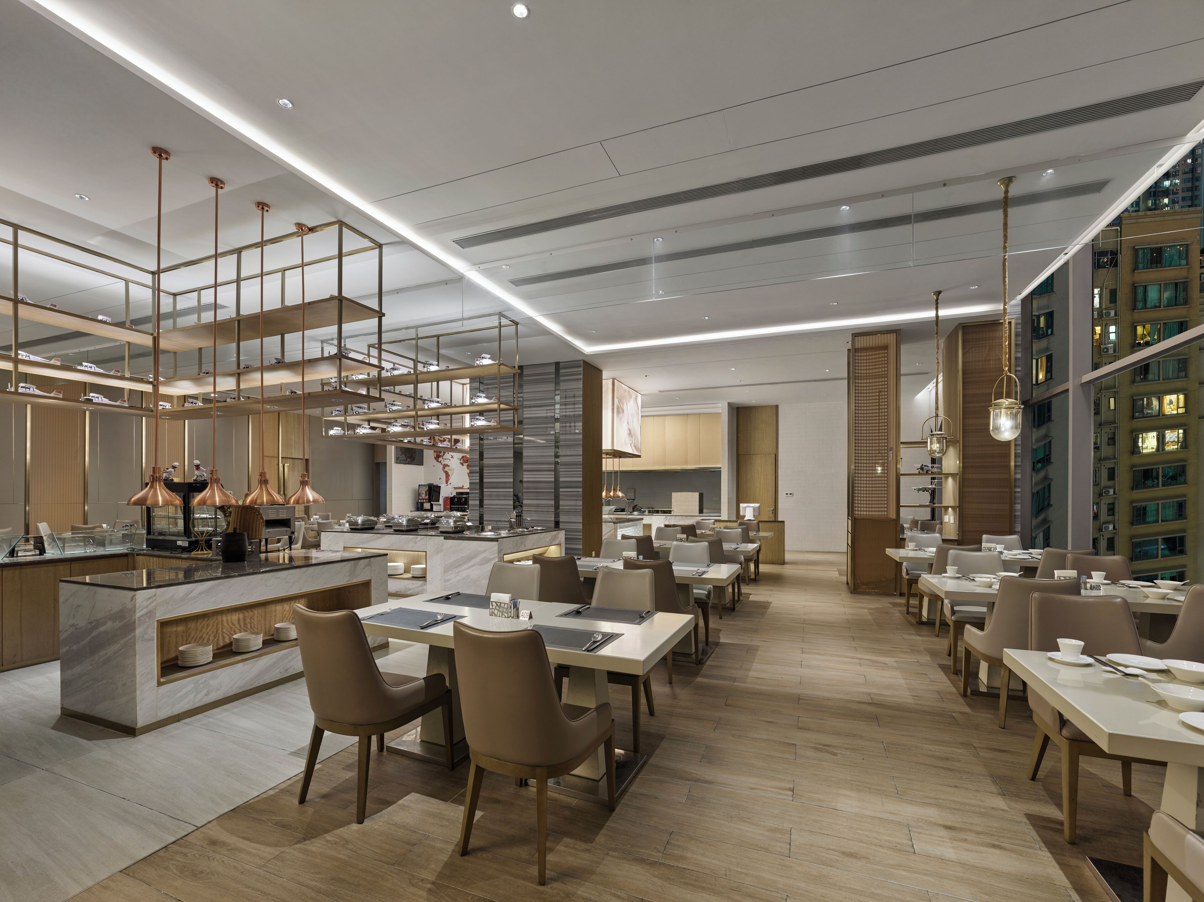 Un ristorante moderno con una sala da pranzo ampia, soffitti alti e lampade dal design contemporaneo.