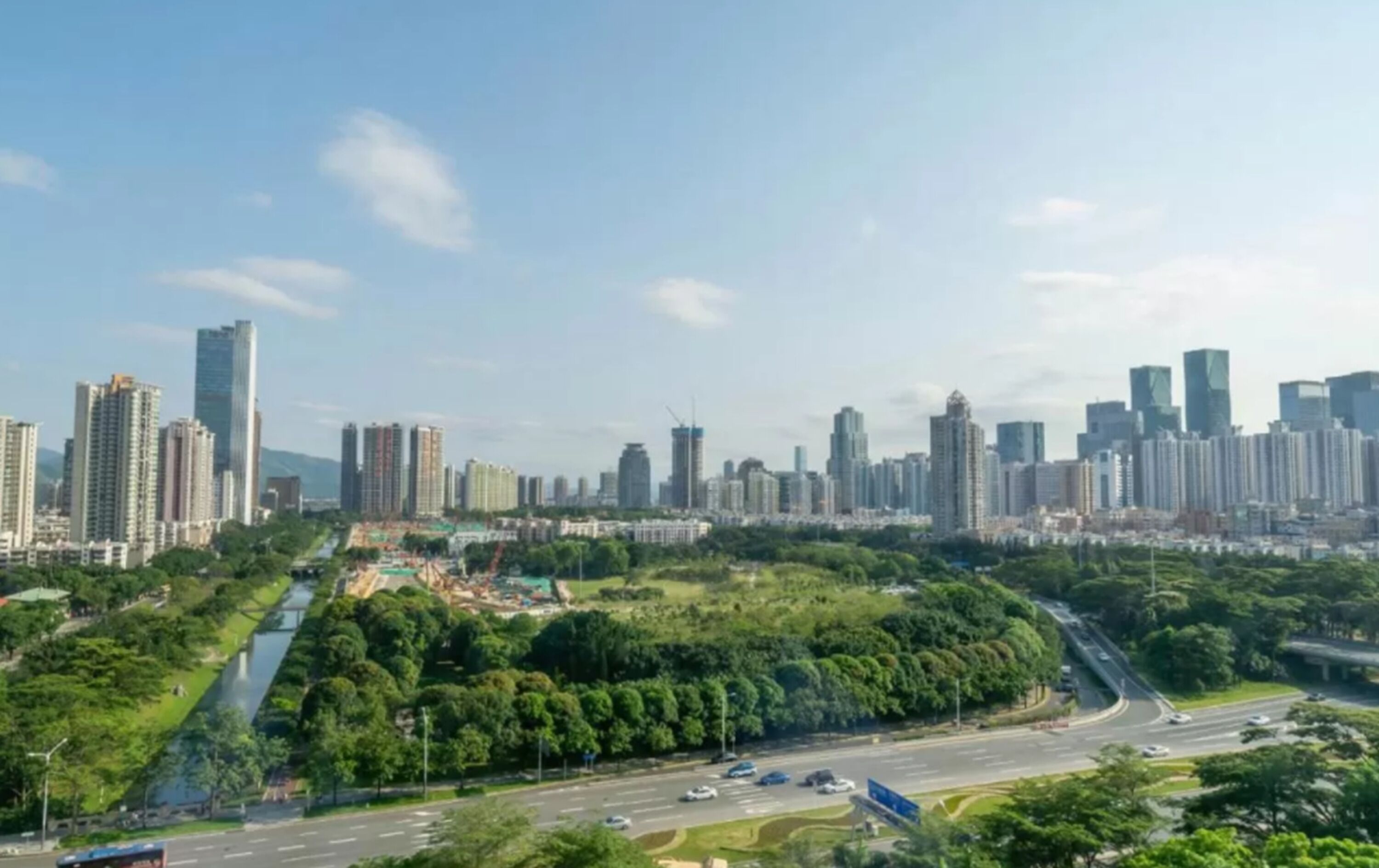 Un paisaje urbano con rascacielos, una autopista y zonas verdes.
