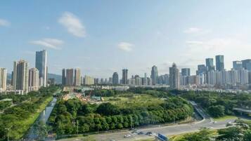 Un paisaje urbano con rascacielos, una autopista y zonas verdes.