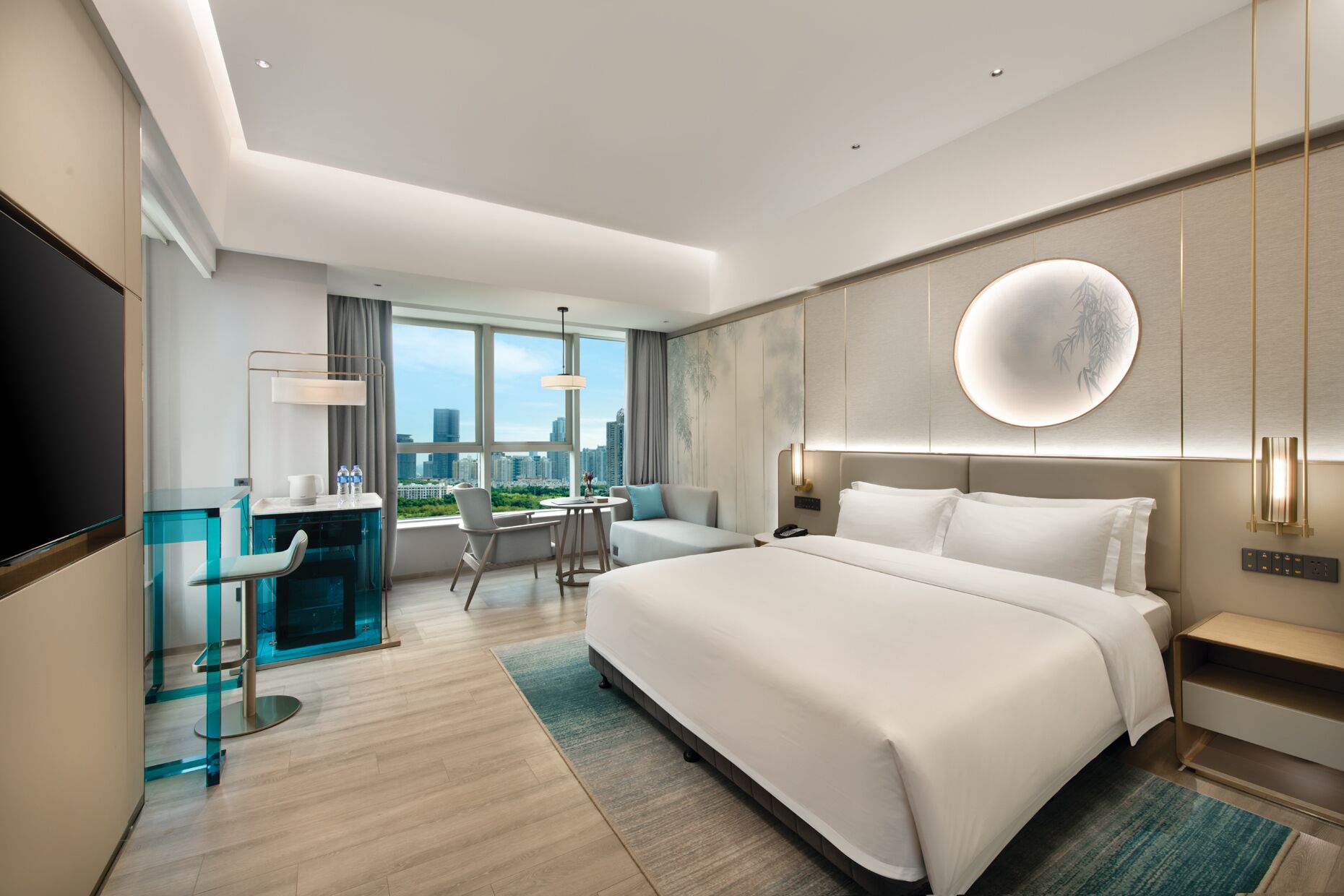 Habitación de hotel moderna con una cama grande, un escritorio y vistas a la ciudad.