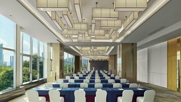A conference room with tables and chairs, large windows, and a city view.
