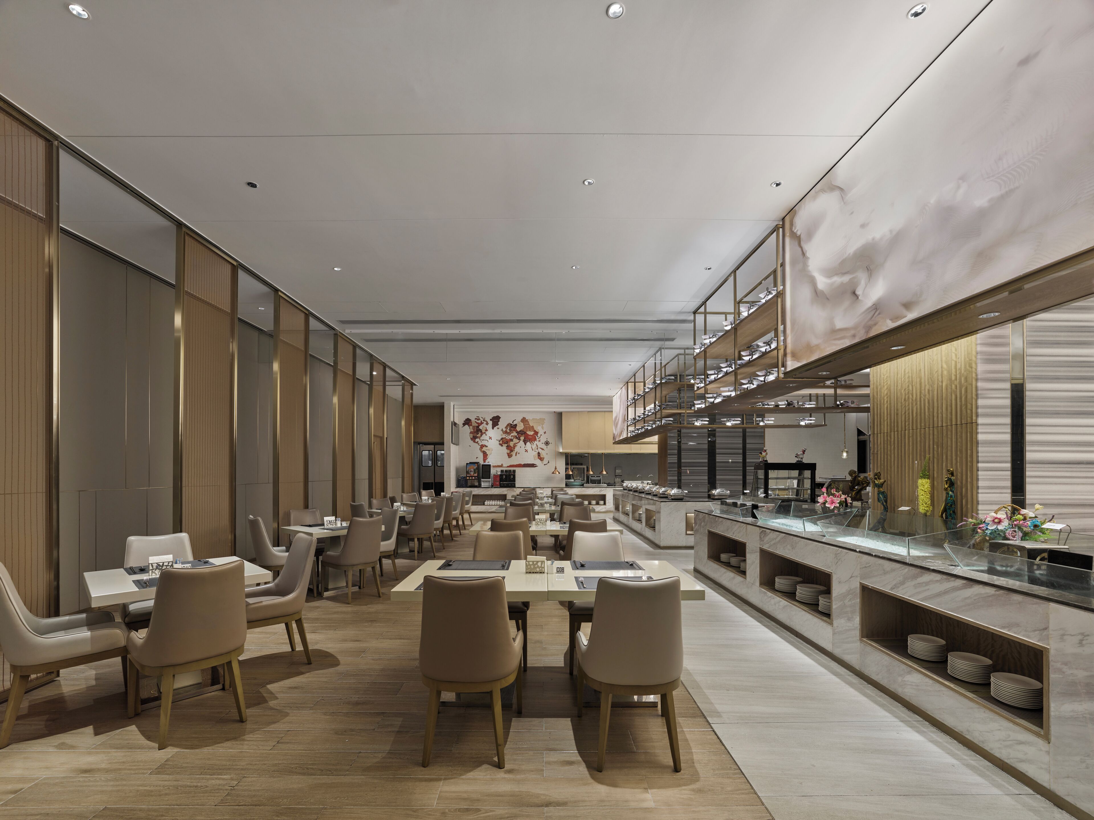 A modern restaurant with a long counter, multiple tables, and chairs.