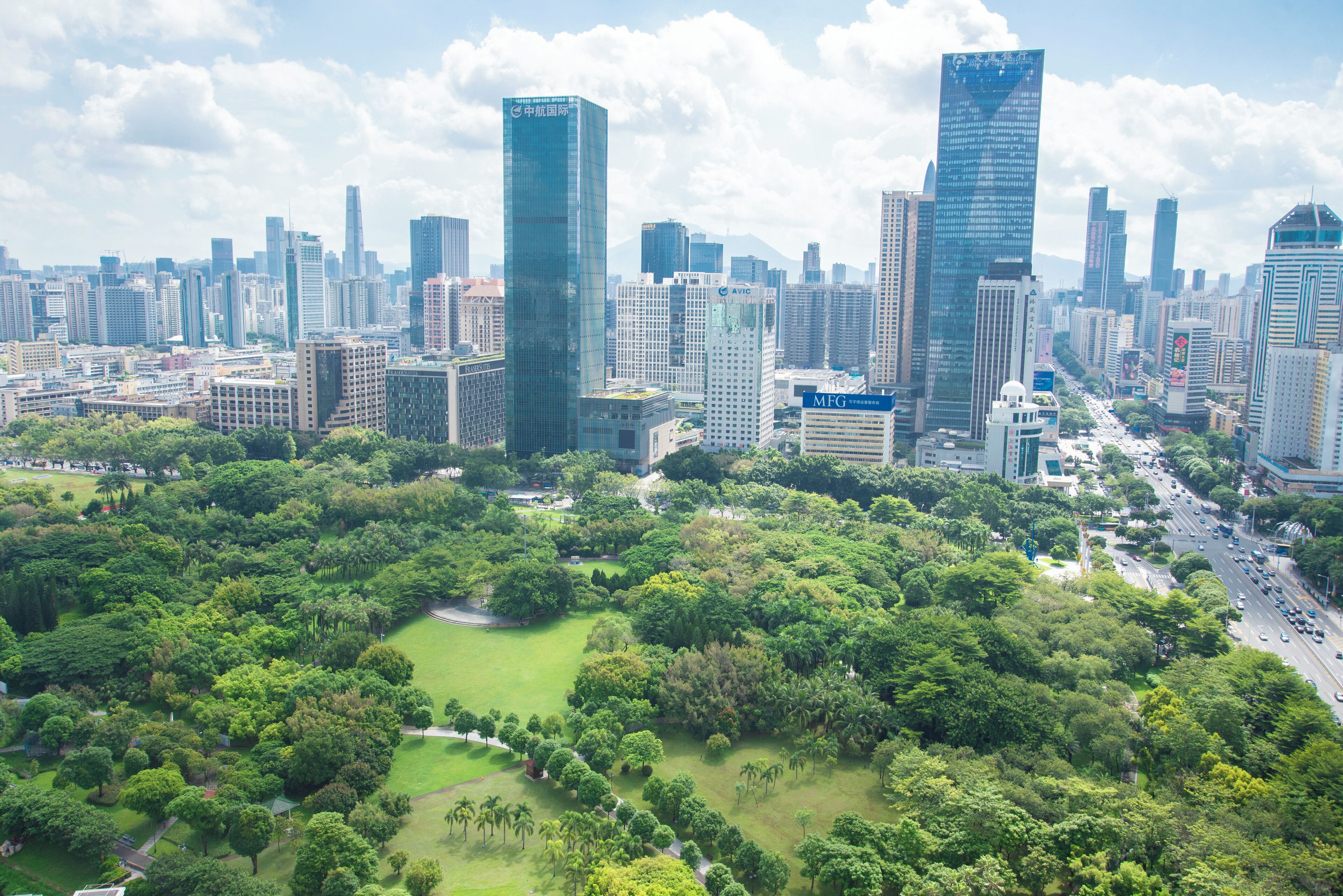 Un paisaje urbano con rascacielos modernos y una zona verde.