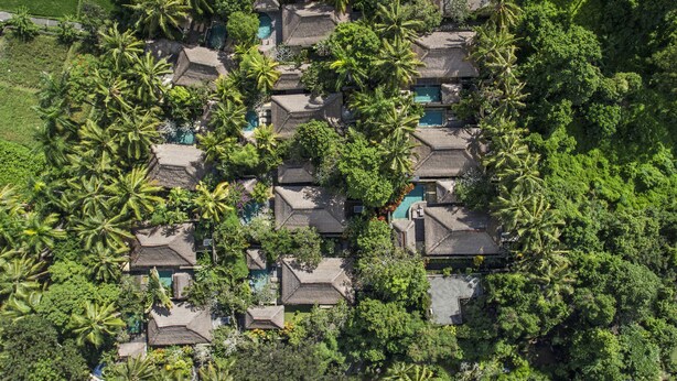 An aerial view of a resort with multiple bungalow-style buildings surrounded by lush greenery and palm trees. - The Ubud Village Resort & Spa (Ubud)