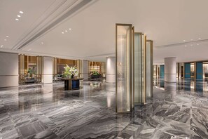 A spacious lobby with a polished marble floor, a reception desk, and a tall, narrow column. - Wyndham Hangzhou Linping (Hangzhou)