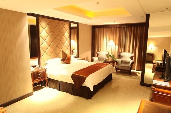 A hotel room with a large bed, a wooden nightstand, a chair, a desk, and a television. - Wyndham Hangzhou Linping (Hangzhou)