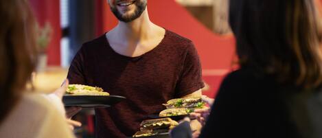 A person serving food to guests in a restaurant setting.