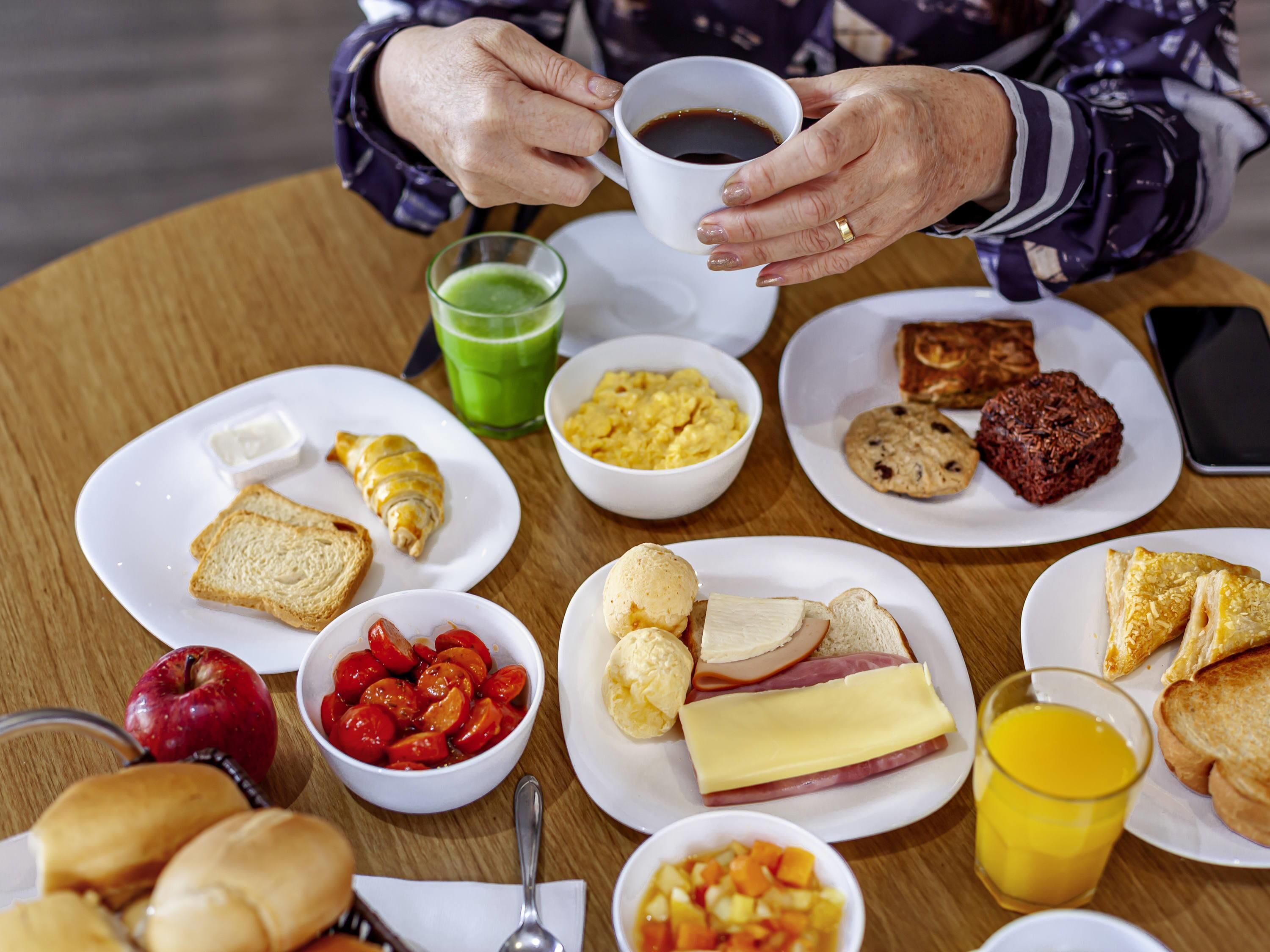 A table with breakfast items including toast, eggs, and a green drink.