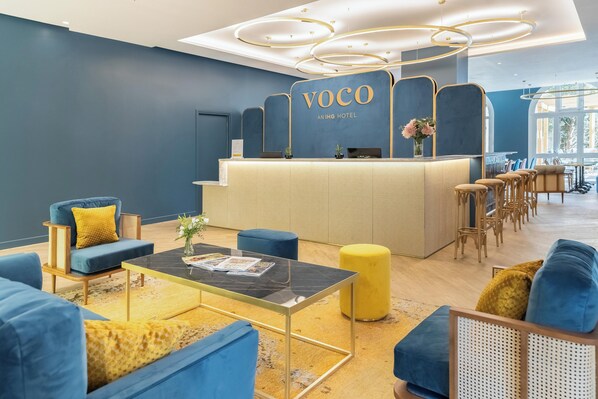 A modern hotel lobby with a reception desk, seating area, and a bar. - voco Paris Montparnasse by IHG (Paris)