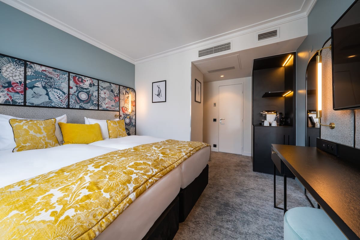 A hotel room with a large bed, a desk, and a TV.