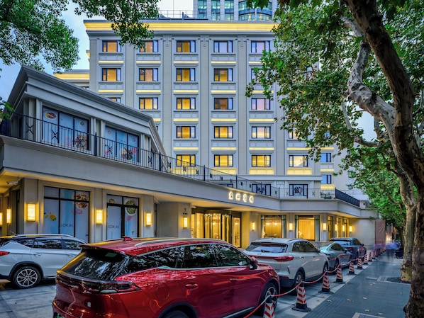 Un hotel con fachada moderna, varios pisos y una entrada destacada con un letrero.