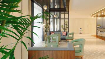 A modern interior with a reception desk, seating area, and large windows.