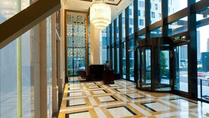 A spacious lobby with a geometric patterned floor, large windows, and a central chandelier. - Paramount Gallery Hotel (Shanghai)