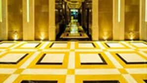 A long, narrow hallway with a checkered floor pattern and tall, reflective walls. - Paramount Gallery Hotel (Shanghai)
