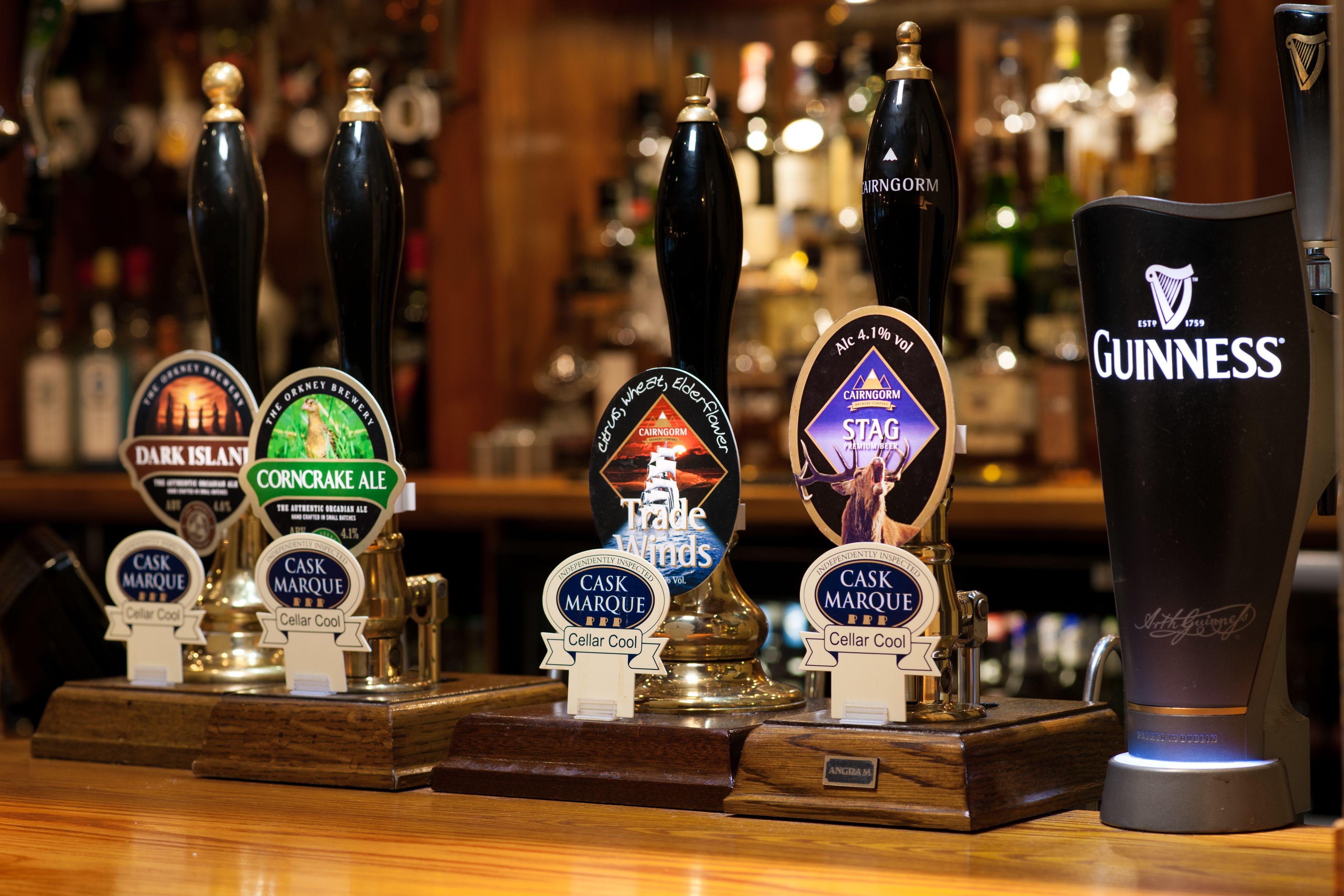 A bar with various beer taps and a Guinness tap.