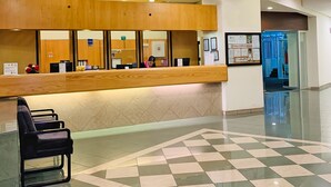A reception area with a wooden counter, a check-in desk, and a tiled floor. - Hotel Lepanto Reforma (Mexico City)