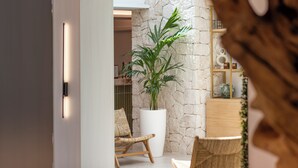 A modern interior with a stone wall, a large potted plant, and a wooden chair. - Valentin Somni Hotels & Suites – Adults Only +16 (Calvia)