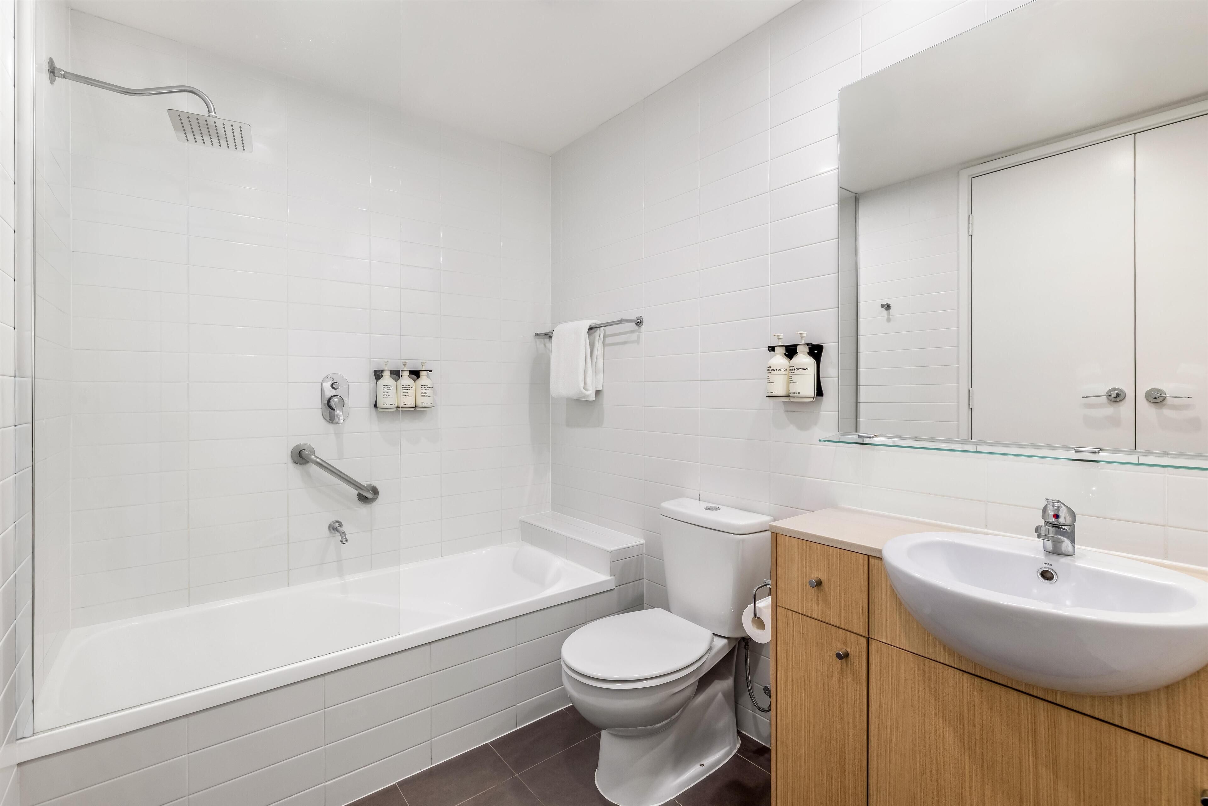 A modern bathroom with a bathtub, toilet, and sink.