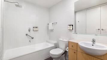 A modern bathroom with a bathtub, toilet, and sink.