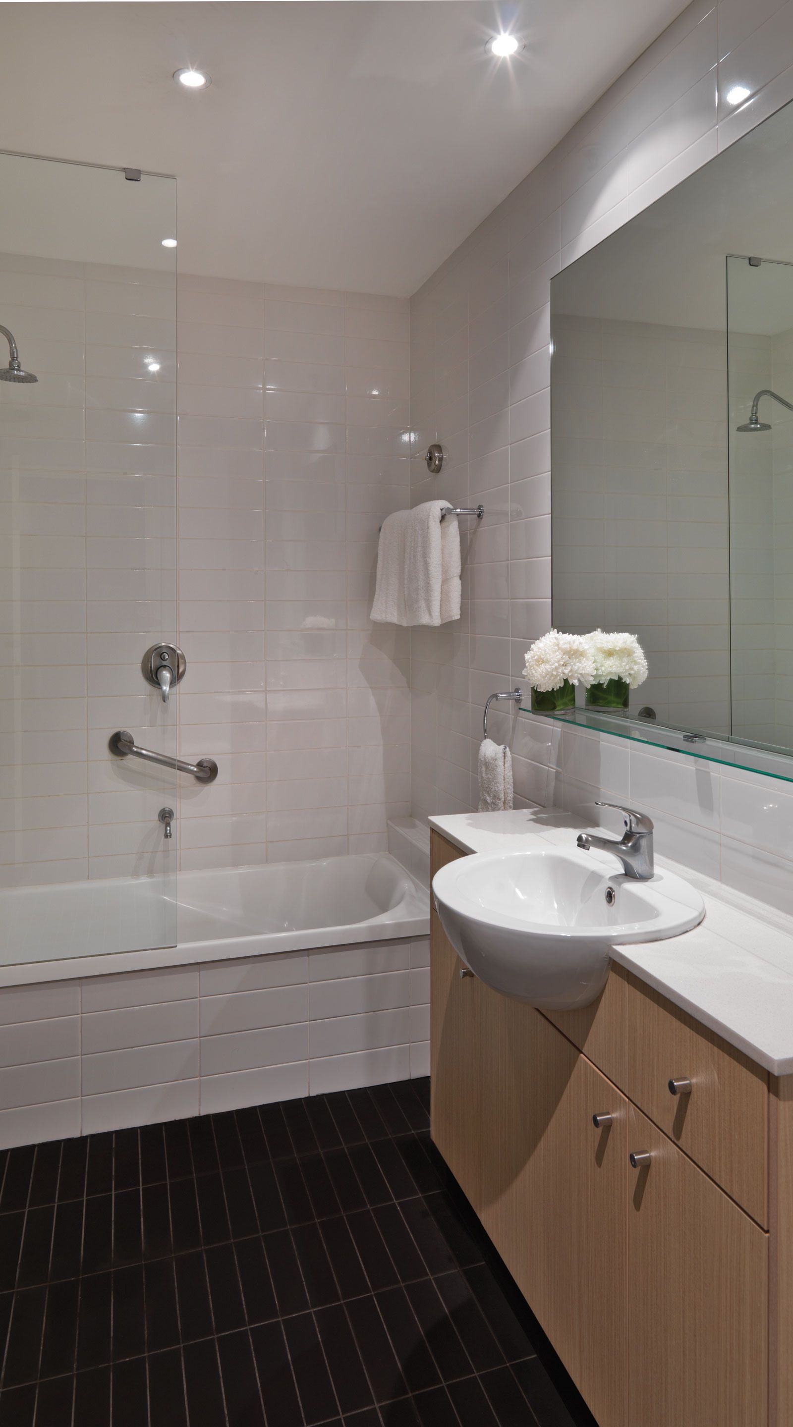 A modern bathroom with a bathtub, a sink, and a glass shower enclosure.