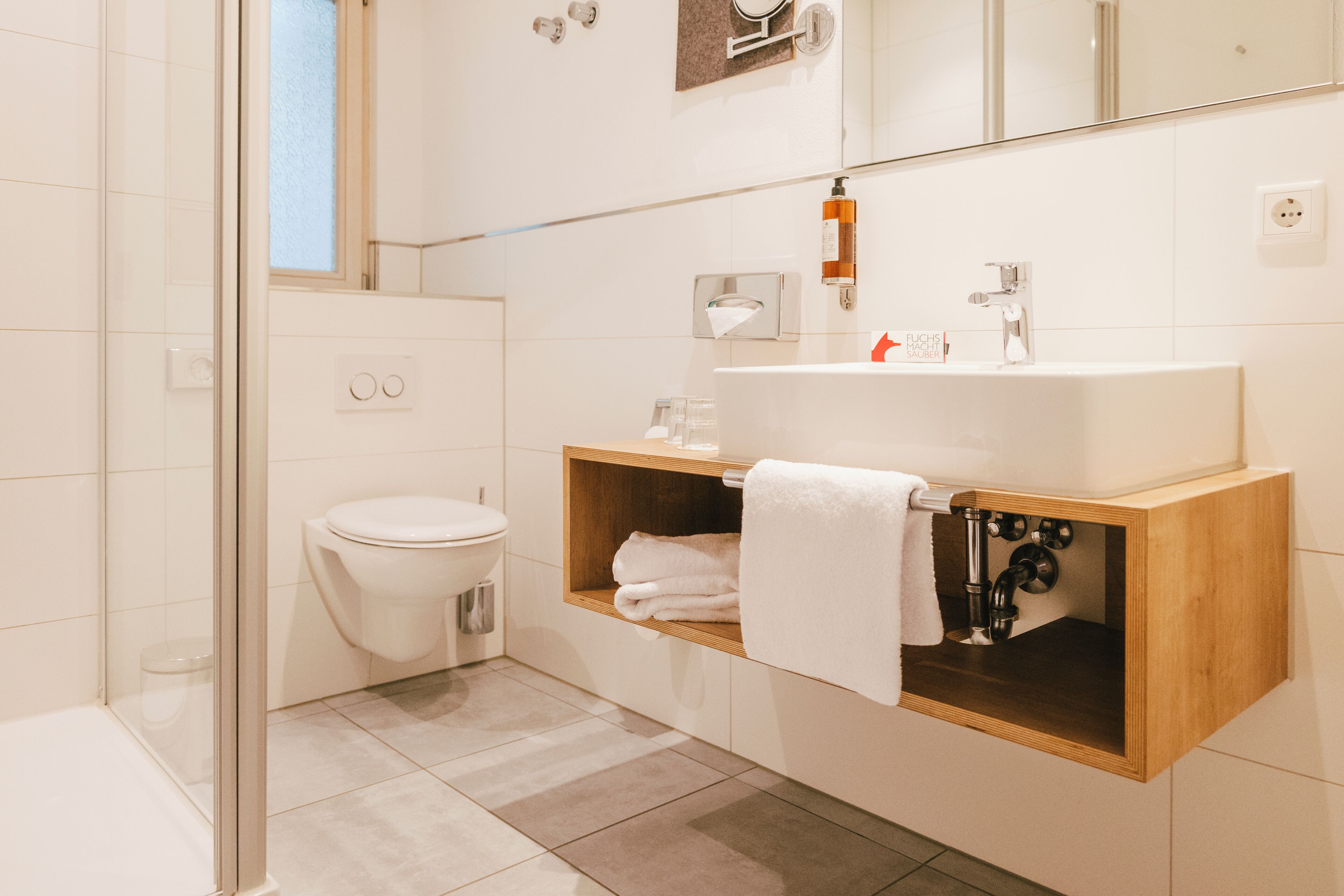A modern bathroom with a toilet, sink, and shower.