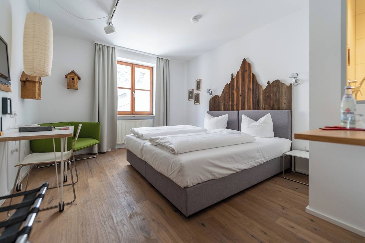 Un dormitorio moderno con una cama grande, un escritorio y dos sillas.
